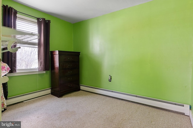 unfurnished bedroom with a baseboard heating unit and carpet floors