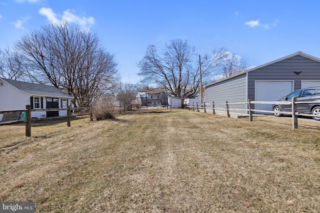 view of yard featuring a trampoline, an outbuilding, and fence