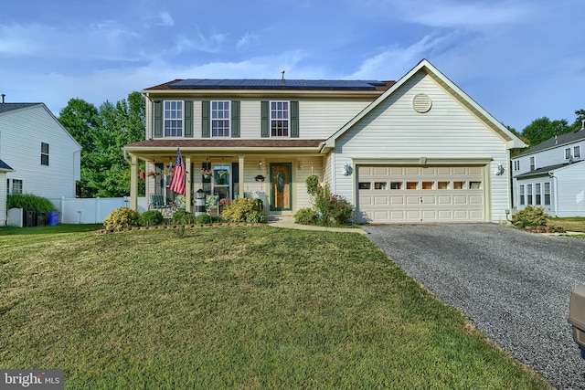 traditional home featuring solar panels, covered porch, an attached garage, driveway, and a front lawn