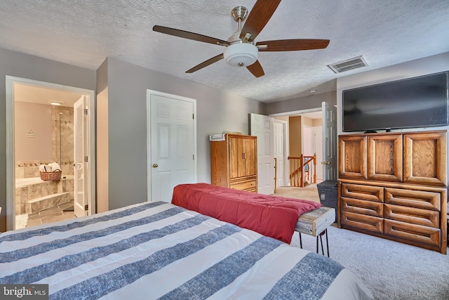 carpeted bedroom featuring a textured ceiling, ceiling fan, connected bathroom, and visible vents