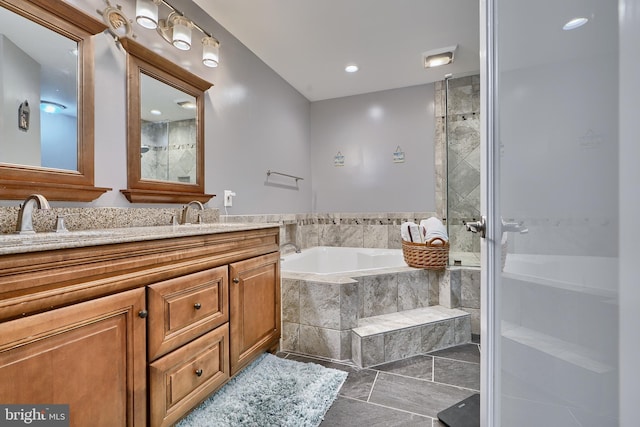 bathroom featuring double vanity, tiled shower, a sink, and a bath