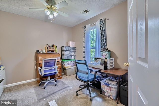 carpeted home office with a ceiling fan, baseboards, visible vents, and a textured ceiling