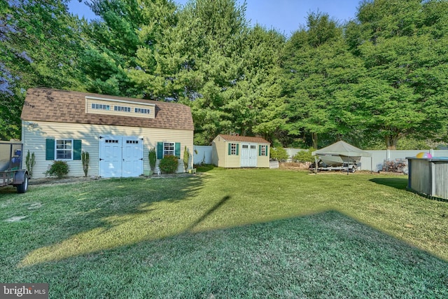 view of yard featuring a storage shed, fence, and an outbuilding