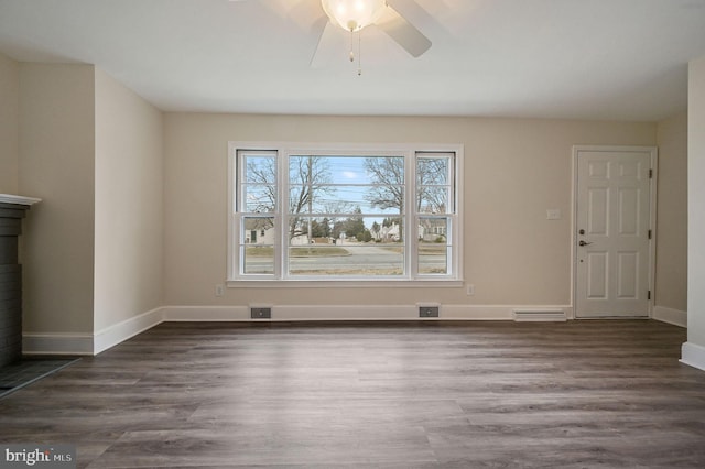 unfurnished living room featuring a ceiling fan, visible vents, baseboards, and wood finished floors