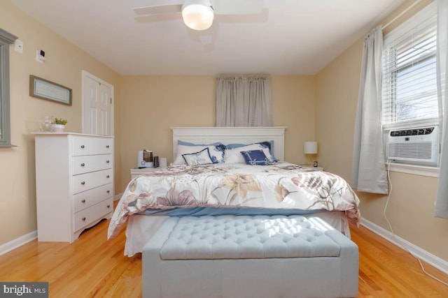 bedroom featuring cooling unit, baseboards, ceiling fan, and light wood finished floors