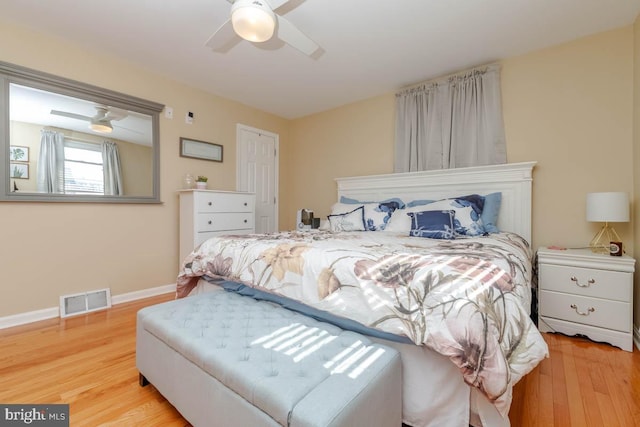 bedroom featuring light wood-type flooring, baseboards, visible vents, and ceiling fan