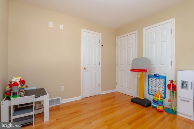 rec room featuring visible vents, baseboards, and wood finished floors