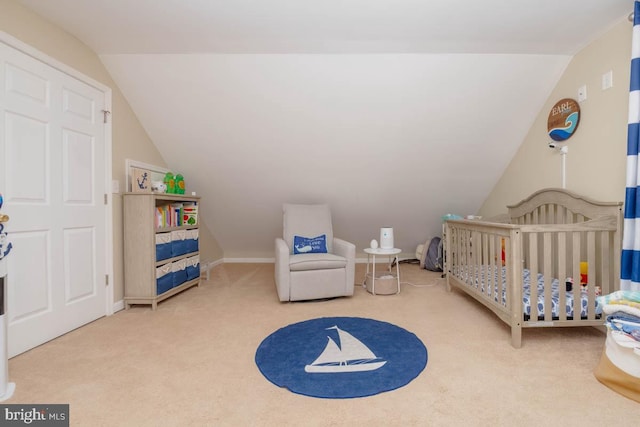 bedroom with lofted ceiling, carpet flooring, and a crib