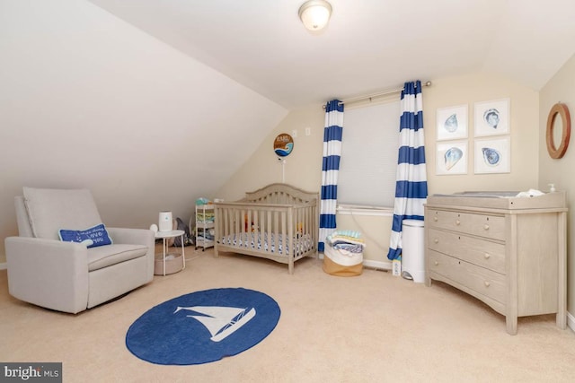 bedroom with lofted ceiling, a nursery area, and light carpet