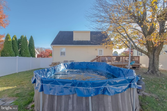 view of swimming pool with a yard, a fenced backyard, a fenced in pool, and a wooden deck