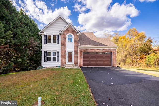 traditional home featuring a garage, brick siding, aphalt driveway, and a front yard