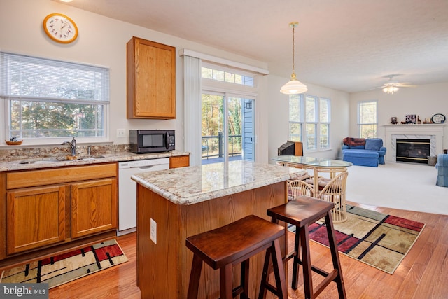 kitchen with dishwasher, plenty of natural light, black microwave, and a sink