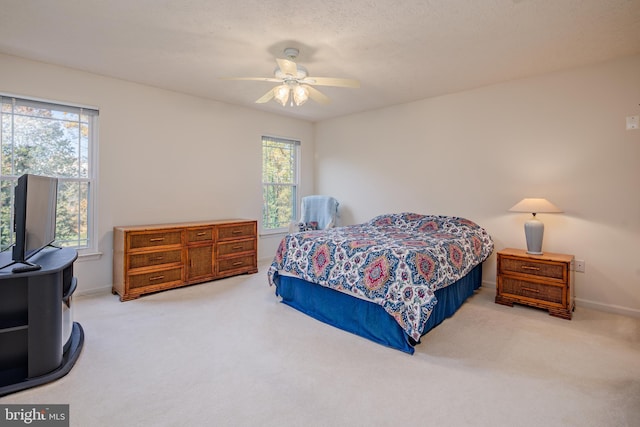 bedroom featuring light colored carpet, ceiling fan, and baseboards