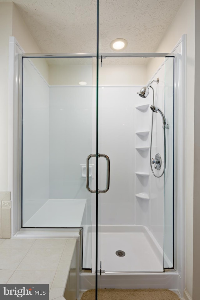 bathroom featuring a stall shower and a textured ceiling