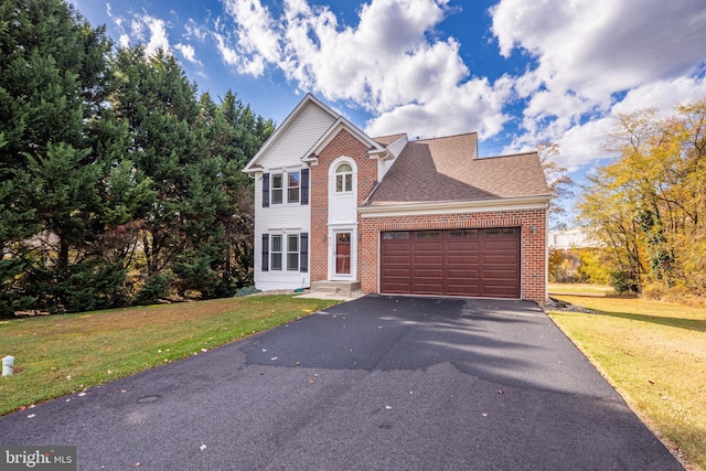 view of front of house with aphalt driveway, a front yard, and brick siding