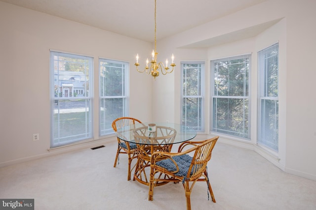 carpeted dining space with an inviting chandelier, baseboards, and visible vents