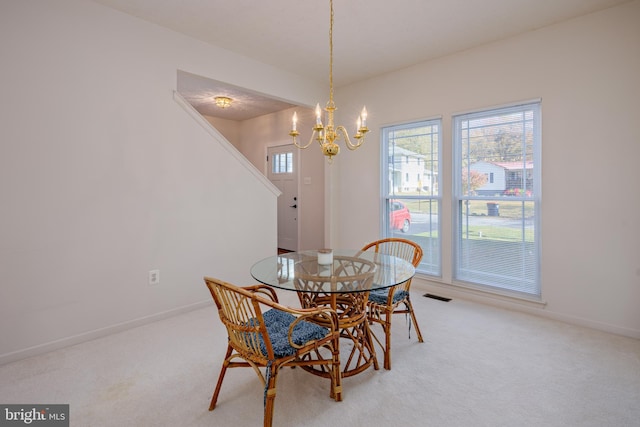 dining room with light colored carpet, visible vents, baseboards, and an inviting chandelier