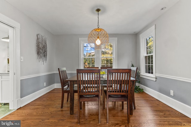 dining space with dark wood-type flooring and baseboards