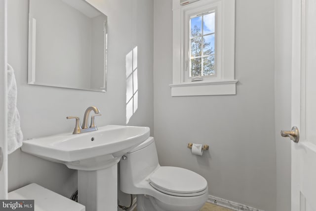 half bath with toilet and baseboards