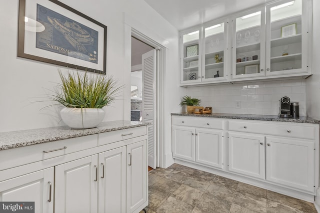 bar with stone finish floor and backsplash