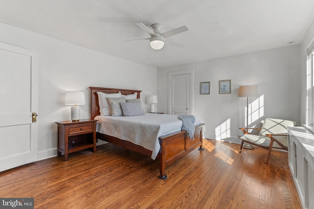 bedroom with multiple windows, ceiling fan, baseboards, and wood finished floors