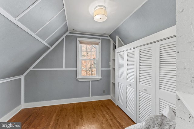 bonus room with vaulted ceiling, baseboards, and wood finished floors