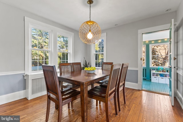 dining space with baseboards, a healthy amount of sunlight, and light wood finished floors