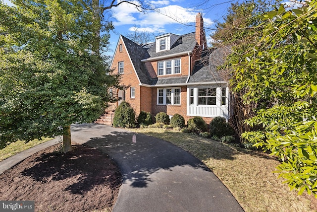 view of front of property featuring brick siding and a chimney