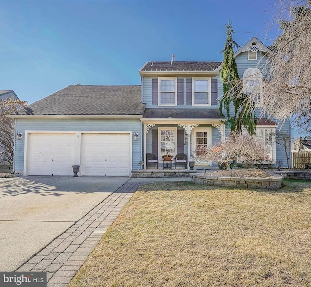 traditional home with a porch, a front yard, driveway, and a garage