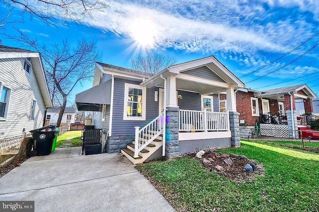 view of front facade featuring fence, a front lawn, and a porch