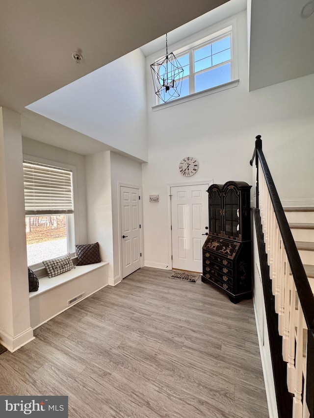 entryway with a healthy amount of sunlight, stairs, and wood finished floors