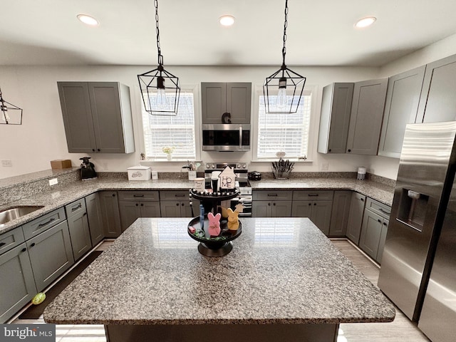 kitchen featuring stainless steel appliances, recessed lighting, gray cabinets, and light stone counters