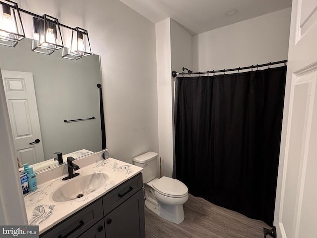 full bathroom featuring a shower with curtain, vanity, toilet, and wood finished floors