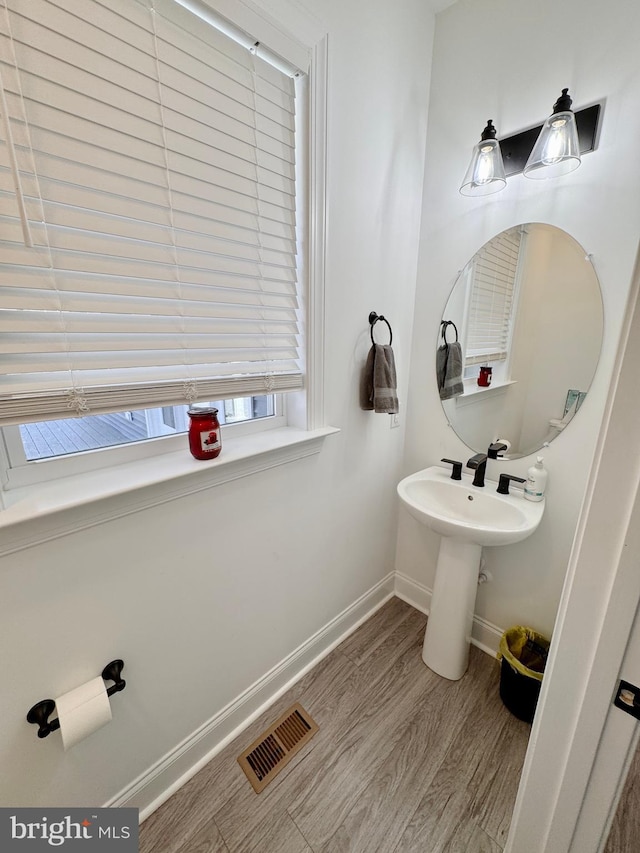 bathroom featuring visible vents, baseboards, and wood finished floors