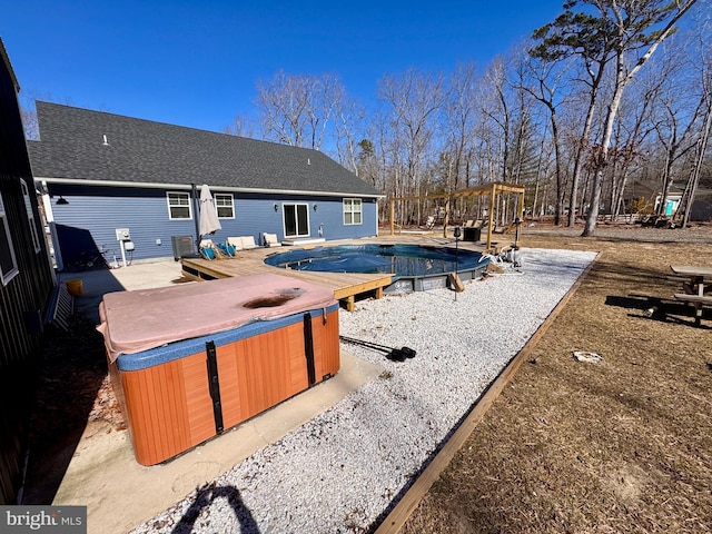 view of pool with a patio area, a covered pool, and a hot tub