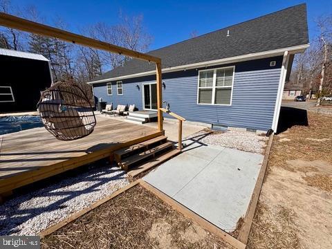 rear view of house with a deck and crawl space