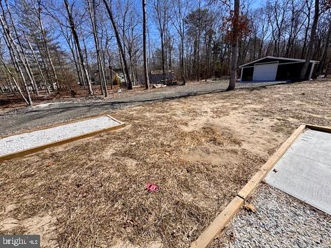 view of yard featuring a detached garage and an outbuilding