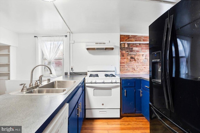 kitchen featuring white appliances, a sink, under cabinet range hood, and blue cabinetry