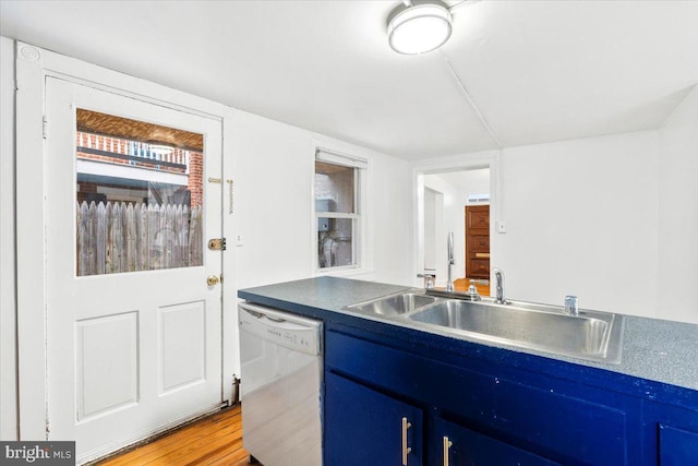 kitchen with dishwasher, wood finished floors, a sink, and blue cabinets