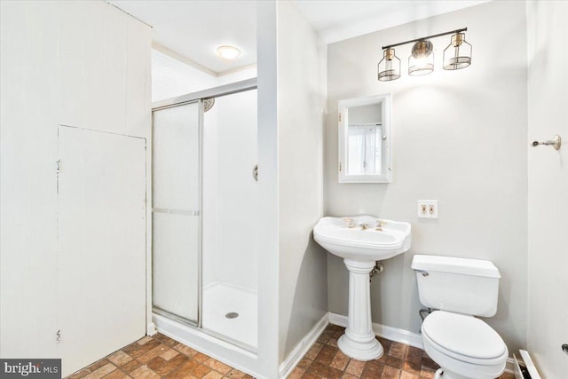 full bath featuring toilet, a shower stall, and baseboards