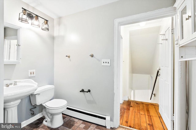 half bathroom featuring toilet, baseboards, and baseboard heating