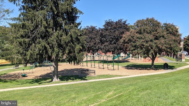 view of property's community with playground community and a yard