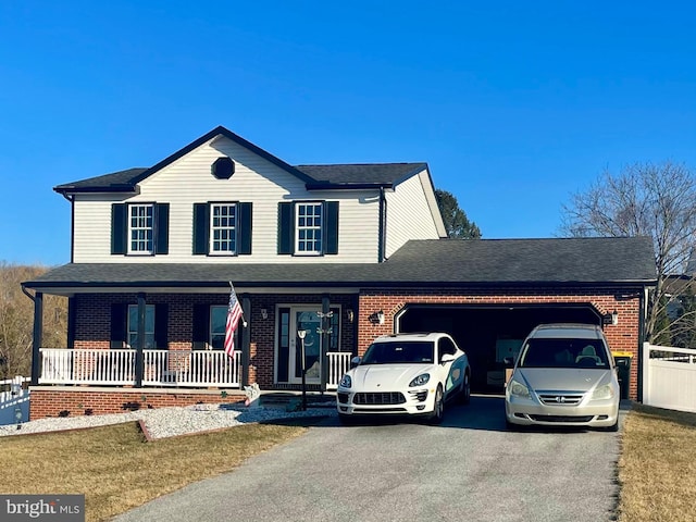 view of front facade with driveway, roof with shingles, a porch, an attached garage, and brick siding