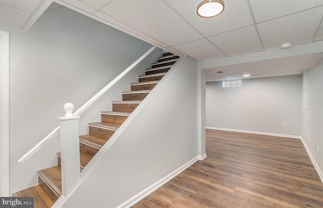 stairs featuring visible vents, a paneled ceiling, baseboards, and wood finished floors