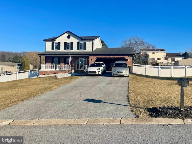 view of front of property featuring a front yard, fence, a garage, and driveway