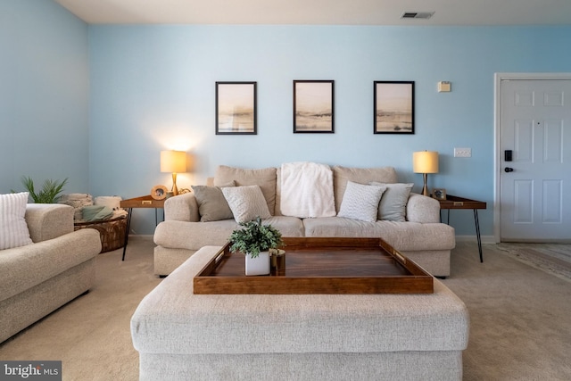 living area featuring visible vents, light carpet, and baseboards