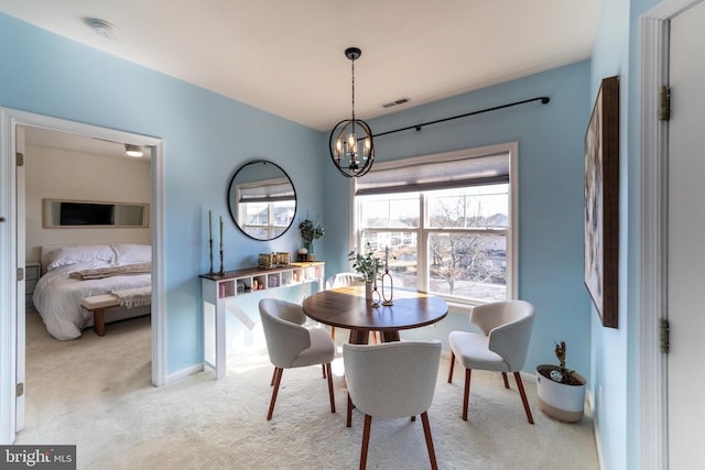 dining space featuring light carpet, a chandelier, visible vents, and baseboards