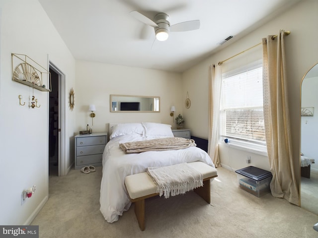 bedroom featuring light carpet, baseboards, visible vents, and a ceiling fan