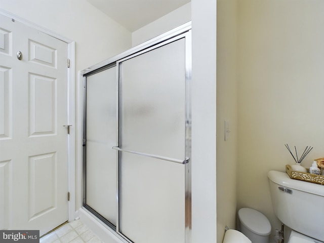 full bath featuring a stall shower and toilet