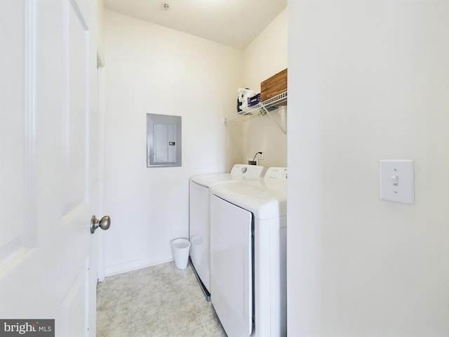 laundry room featuring baseboards, laundry area, electric panel, and washer and dryer